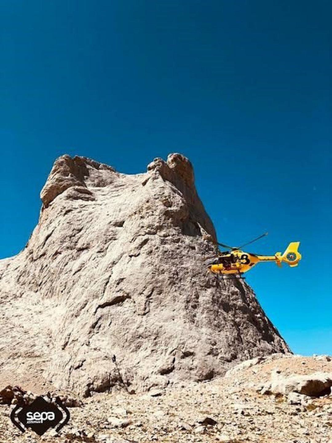 El helicóptero de Bomberos de Asturias pasa frente al Pico Urriellu