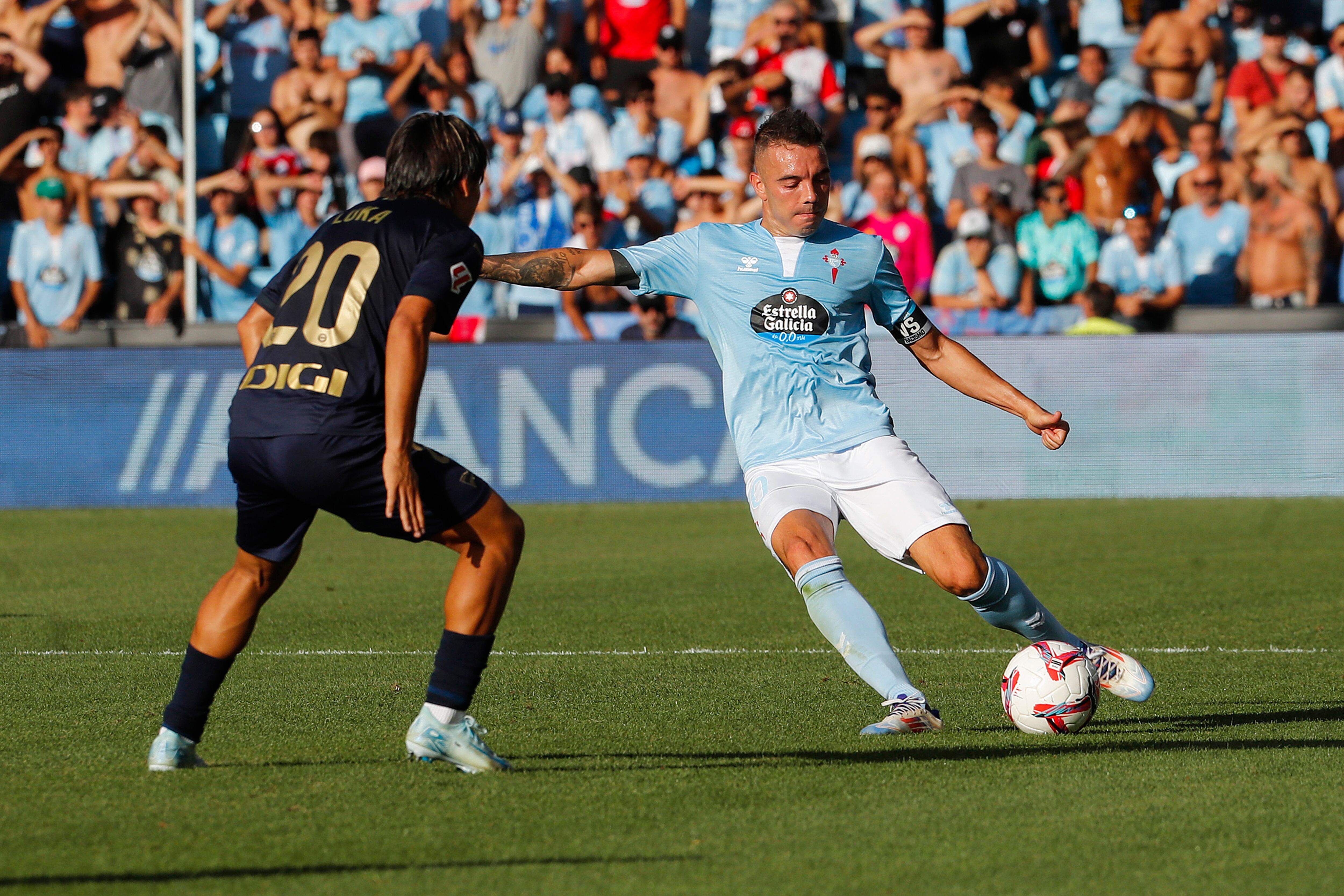 VIGO (PONTEVEDRA), 16/08/2024.- El delantero del Celta de Vigo Iago Aspas (d) pelea un balón con el centrocampista del Alavés Luka Romero, en el partido de LaLiga ante el Alavés disputado este viernes en el estadio Balaidos de Vigo. EFE / Salvador Sas
