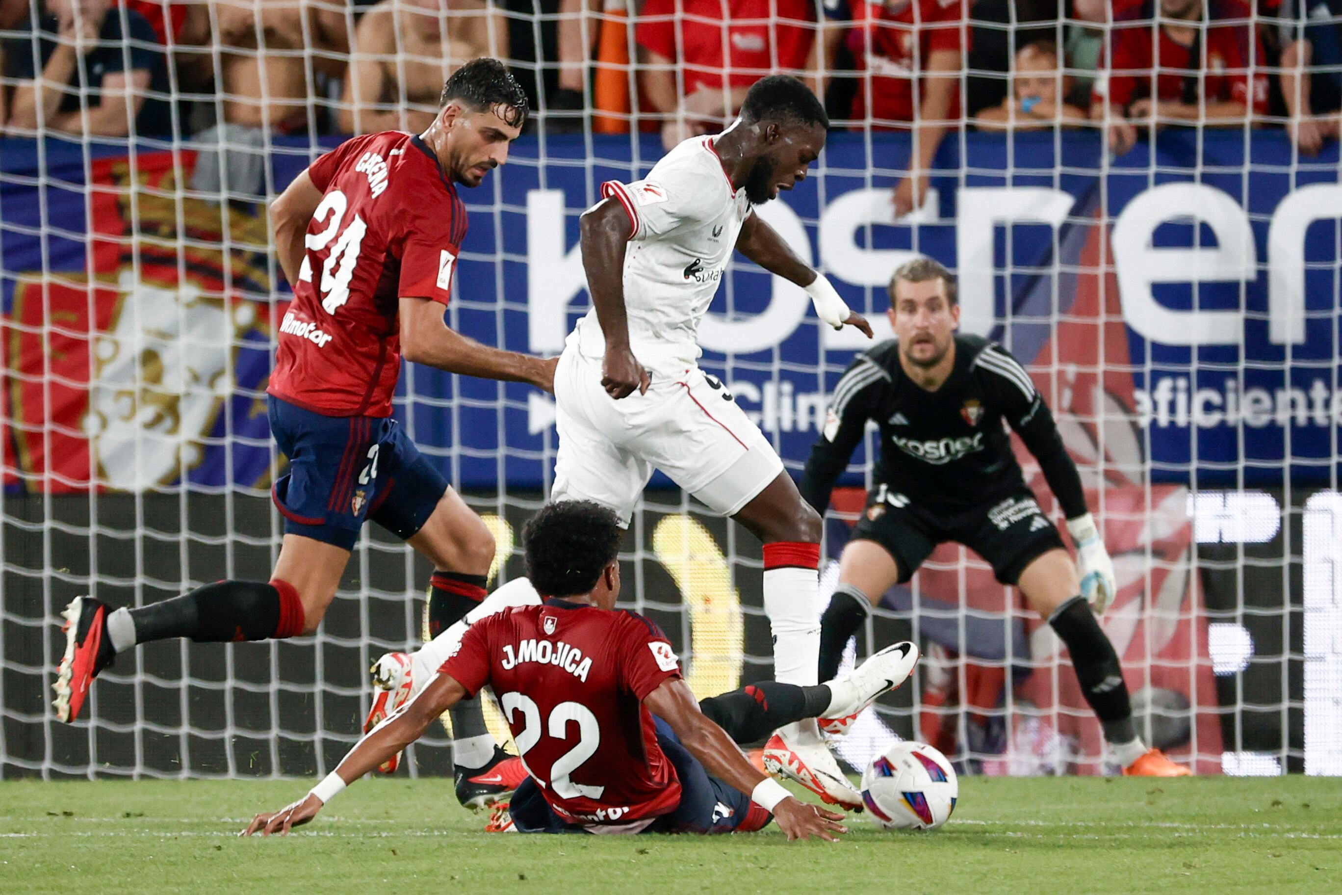 PAMPLONA, 19/08/2023.- Iñaki Williams (c) disputa una posesión en el área del equipo rojillo ante el defensa colombiano de Osasuna Johan Mojica (suelo) durante el partido de la segunda jornada de LaLiga que Atlético Osasuna y Athletic de Bilbao disputan este sábado en el estadio de El Sadar, en Pamplona. EFE/Jesús Diges
