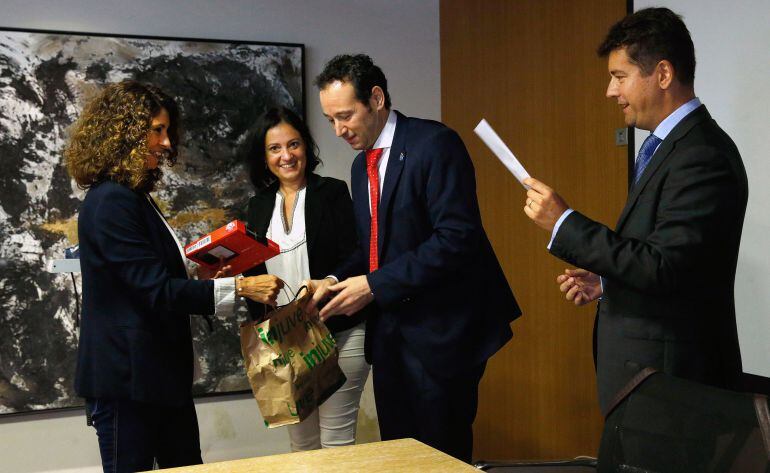 El consejero de Presidencia y Participación Ciudadana, Guillermo Martínez, hace entrega del galardón a la profesora del IES Pando, en presencia de  la directora general del Instituto Asturiano de la Mujer y Políticas de Juventud, Almudena Cueto, y de Iván