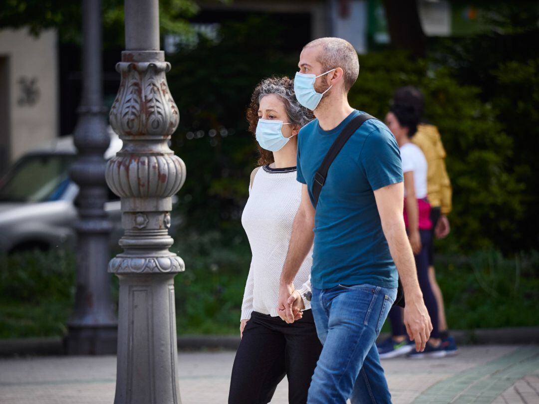 Una pareja camina con mascarillas para protegerse del coronavirus durante el día 54 del estado de alarma en Pamplona