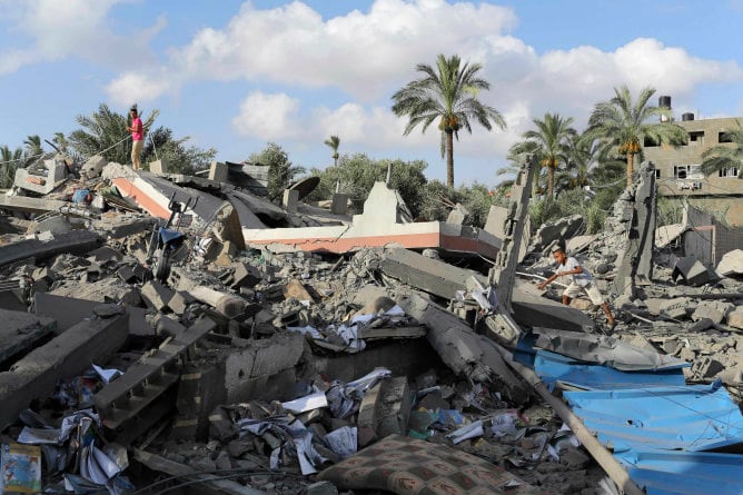 Un niño palestino camina entre los escombros de una casa que fue destruida en un ataque aéreo israelí en Deir El-Balah, en el centro de la Franja de Gaza