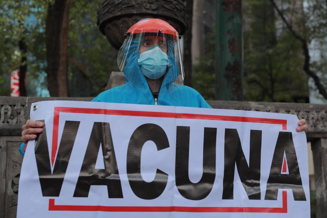Un médico protesta con un cartel que dice "Vacuna" para exigir la aplicación de la vacuna contra la covid-19, en Ciudad de México (México).
