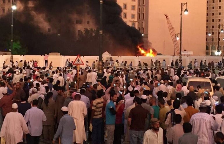 Los saudíes presencian el fuego provocado tras la explosión provocada por un terrorista suicida en la mezquita del Profeta, en la ciudad de Medina