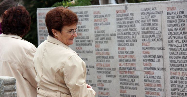 Una dona observa els noms escrits del monument a les víctimes de la Guerra inaugurat al 2010 al cementiri de Lleida