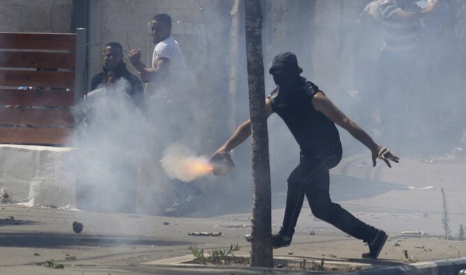 Varios palestinos se enfrentan a soldados israelíes durante el funeral del adolescente Muhammed Abu Khdair