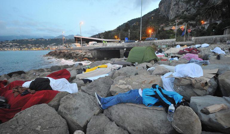 Inmigrantes indocumentados descansan en las rocas del Puente de San Ludovico en la localidad fronteriza de Ventimiglia (Italia).