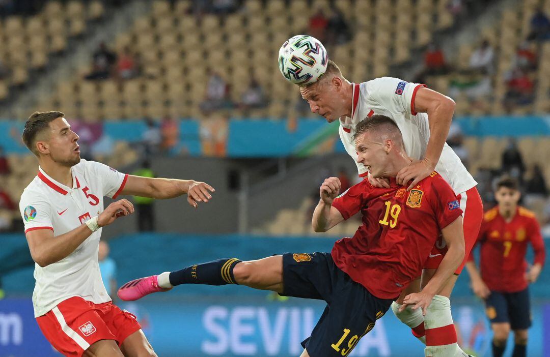 Dani Olmo pelea un balón por alto con la defensa de Polonia