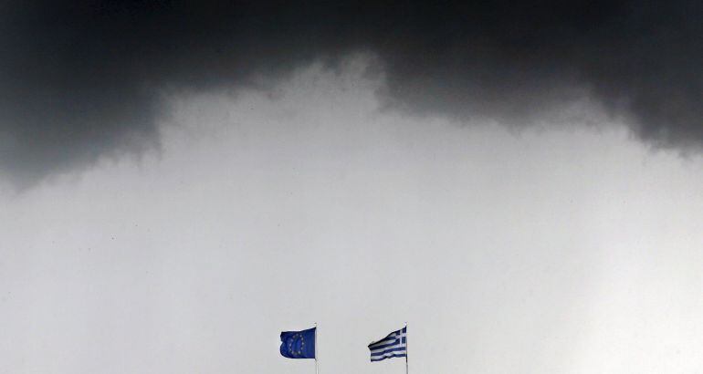 Banderas de Grecia y la Unión Europea, amenazadas por una tormenta en Atenas.