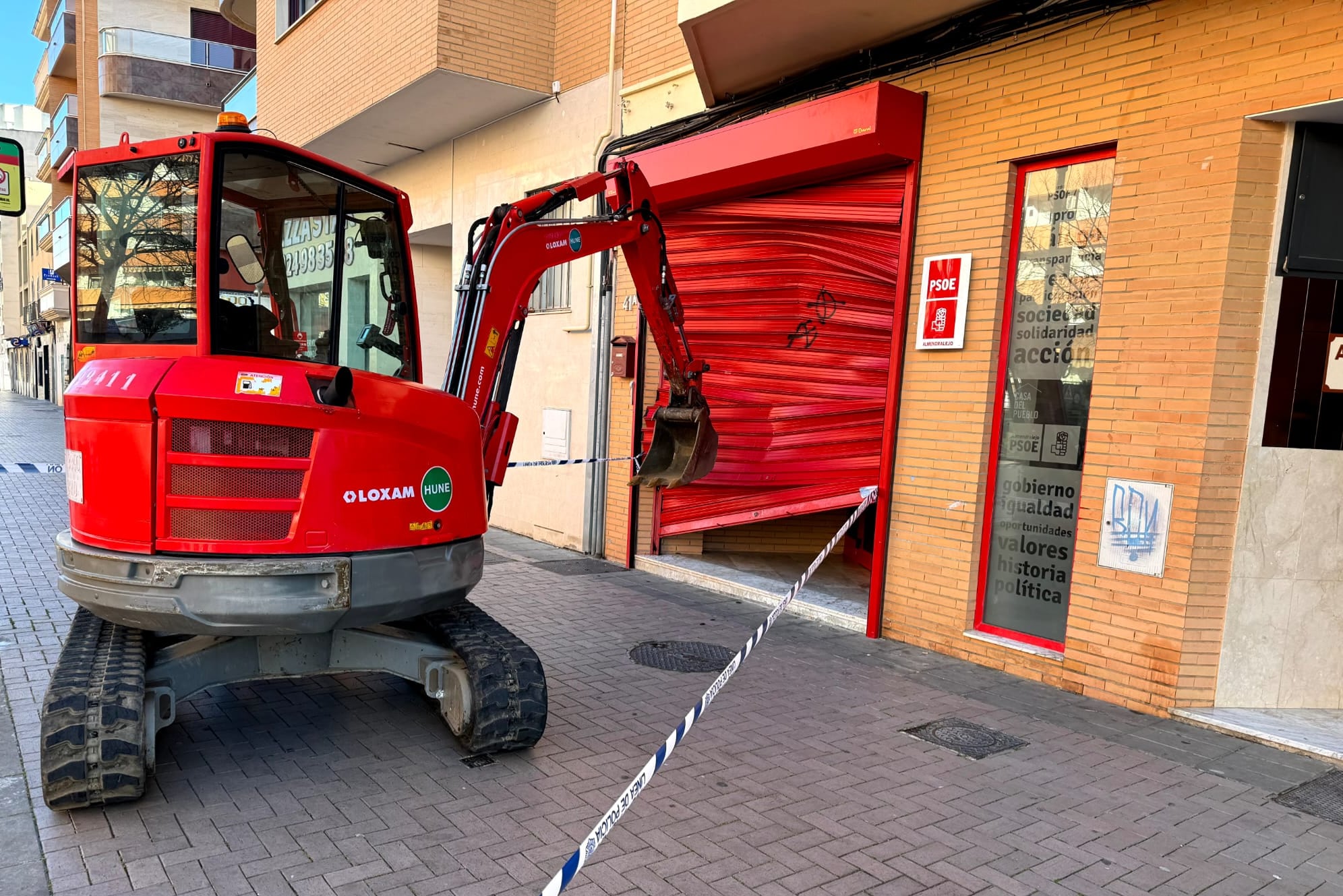 Vista de la sede del PSOE de Almendralejo (Badajoz) tras el ataque con una retroexcavadora que ha reventado la puerta principal.