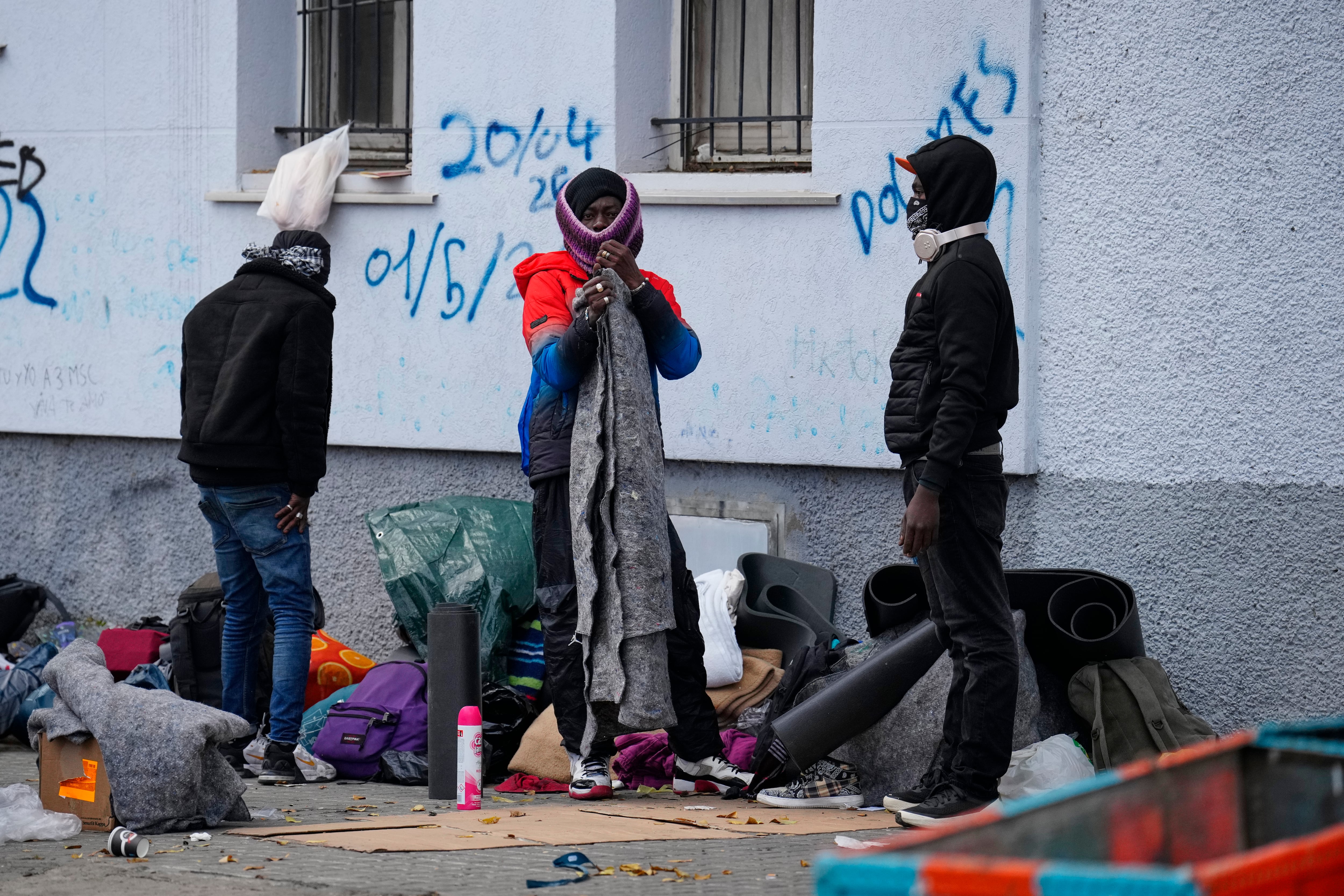 GRAFCAT5952. BADALONA (BARCELONA), 19/12/2025.- El centenar de migrantes acampados en una plaza junto al antiguo instituto B9 de Badalona (Barcelona) desalojado el pasado miércoles por los Mossos d'Esquadra han comenzado a recoger sus pertenencias y abandonar el lugar, después de que la Guardia Urbana les haya emplazado a retirarse. EFE/Alejandro Garcia