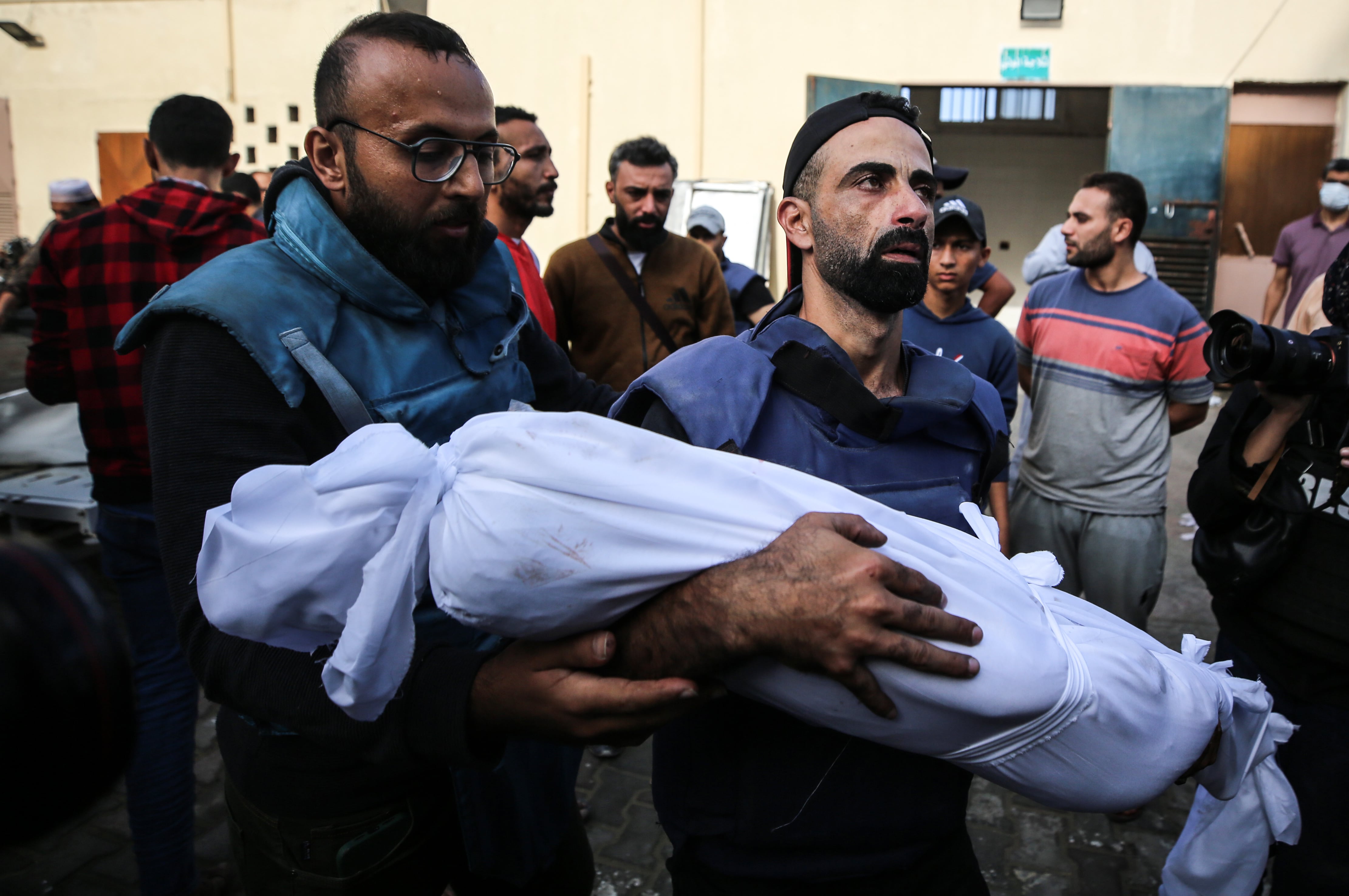 Un palestino carga el cuerpo de uno de sus hijos asesinado en un ataque aéreo de Israel