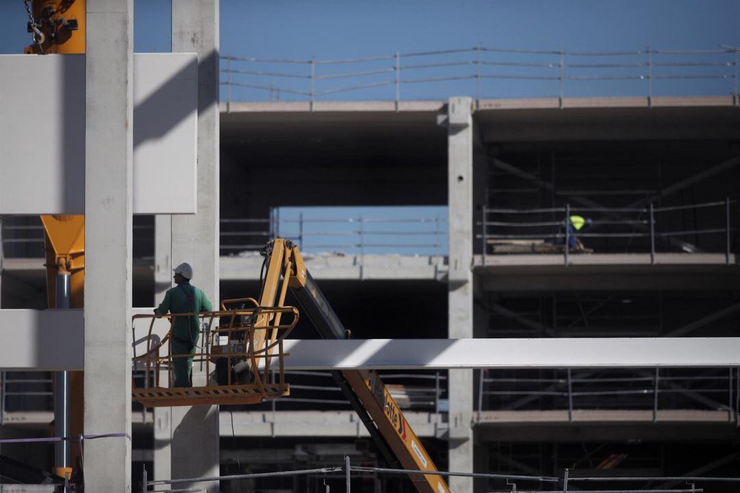 Varios obreros trabajan con maquinaria de construcción