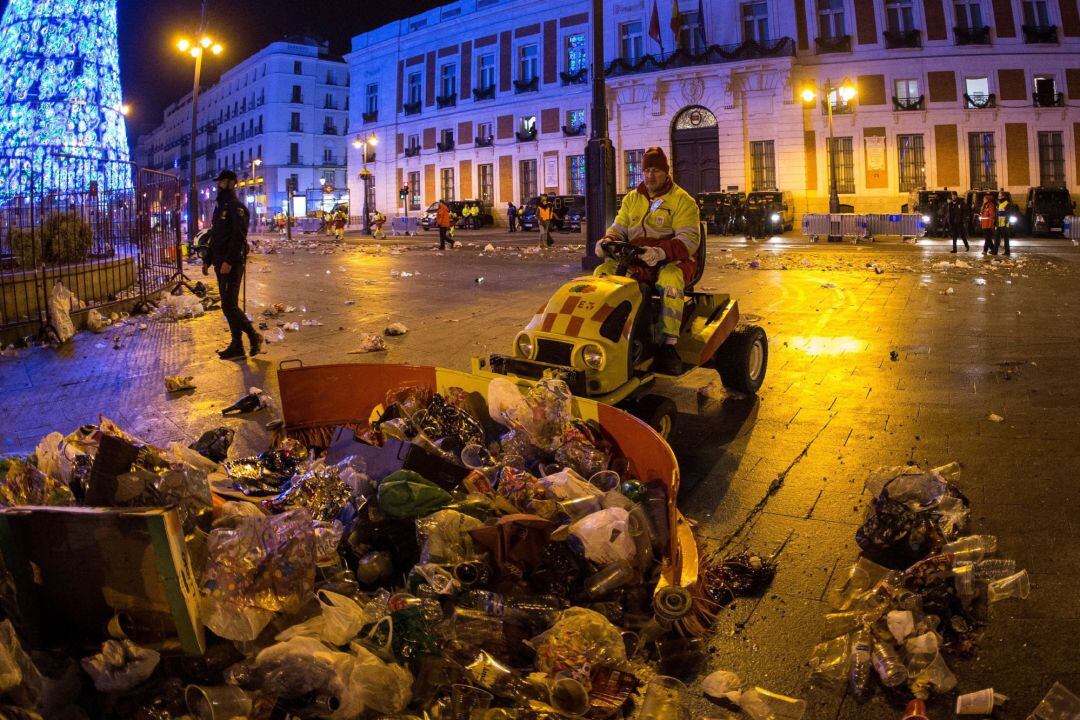 Los servicios de limpieza retiran de madrugada los residuos que han dejado las celebraciones de fin de año en la madrileña Puerta del Sol. 