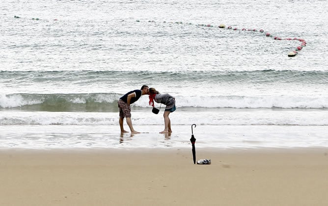 Una pareja disfruta en la playa de La Concha de San Sebastián durante una tregua otorgada por la lluvia