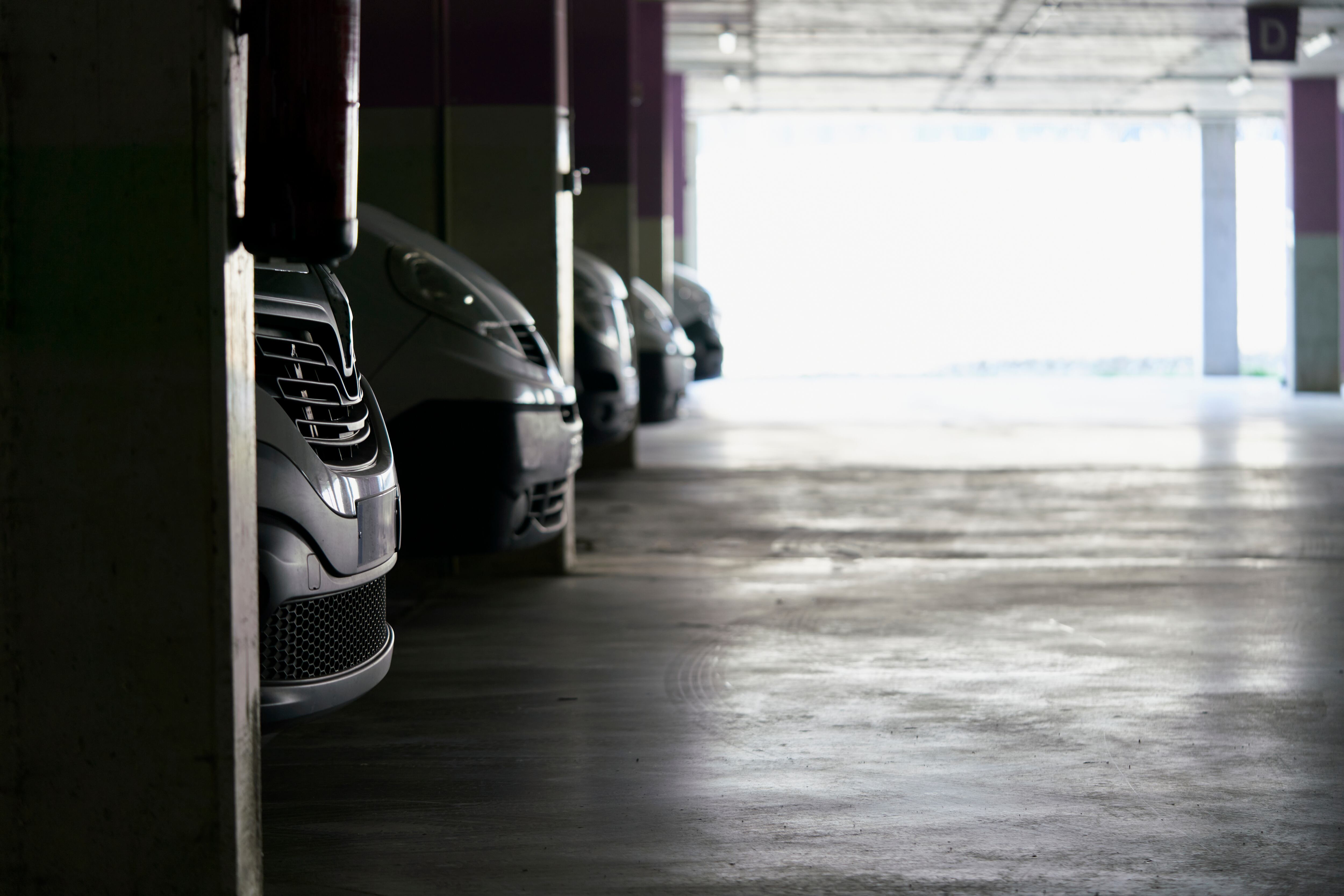 Close-up of front bumpers of parked cars. Parking lot with cars.