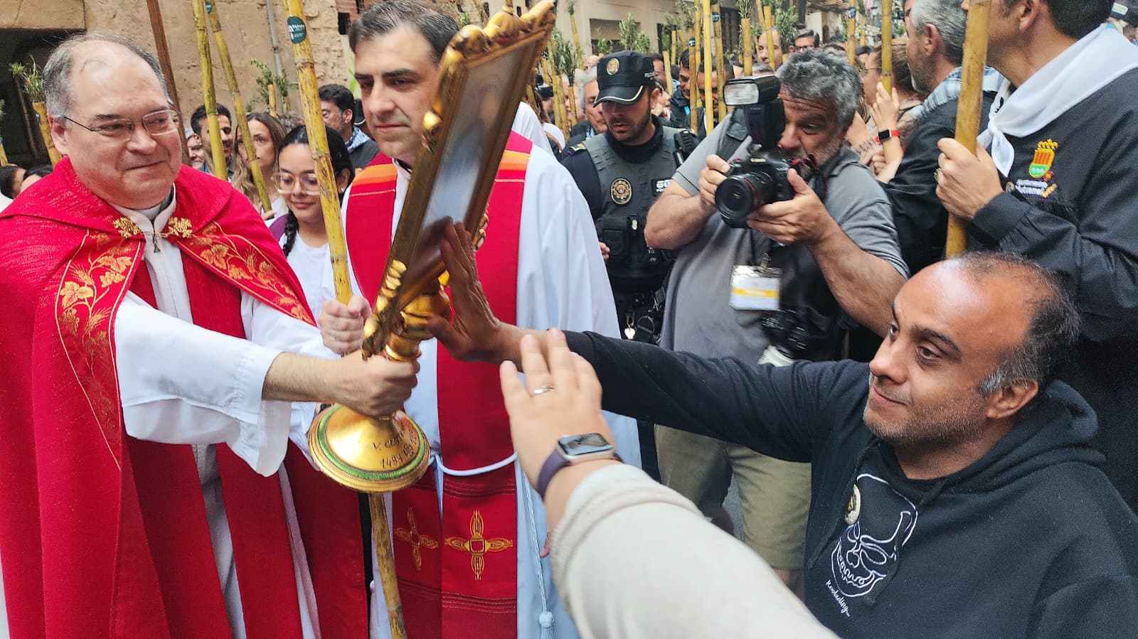Un devoto con movilidad reducida toca la Santa Faz al inicio de la Peregrina 2026