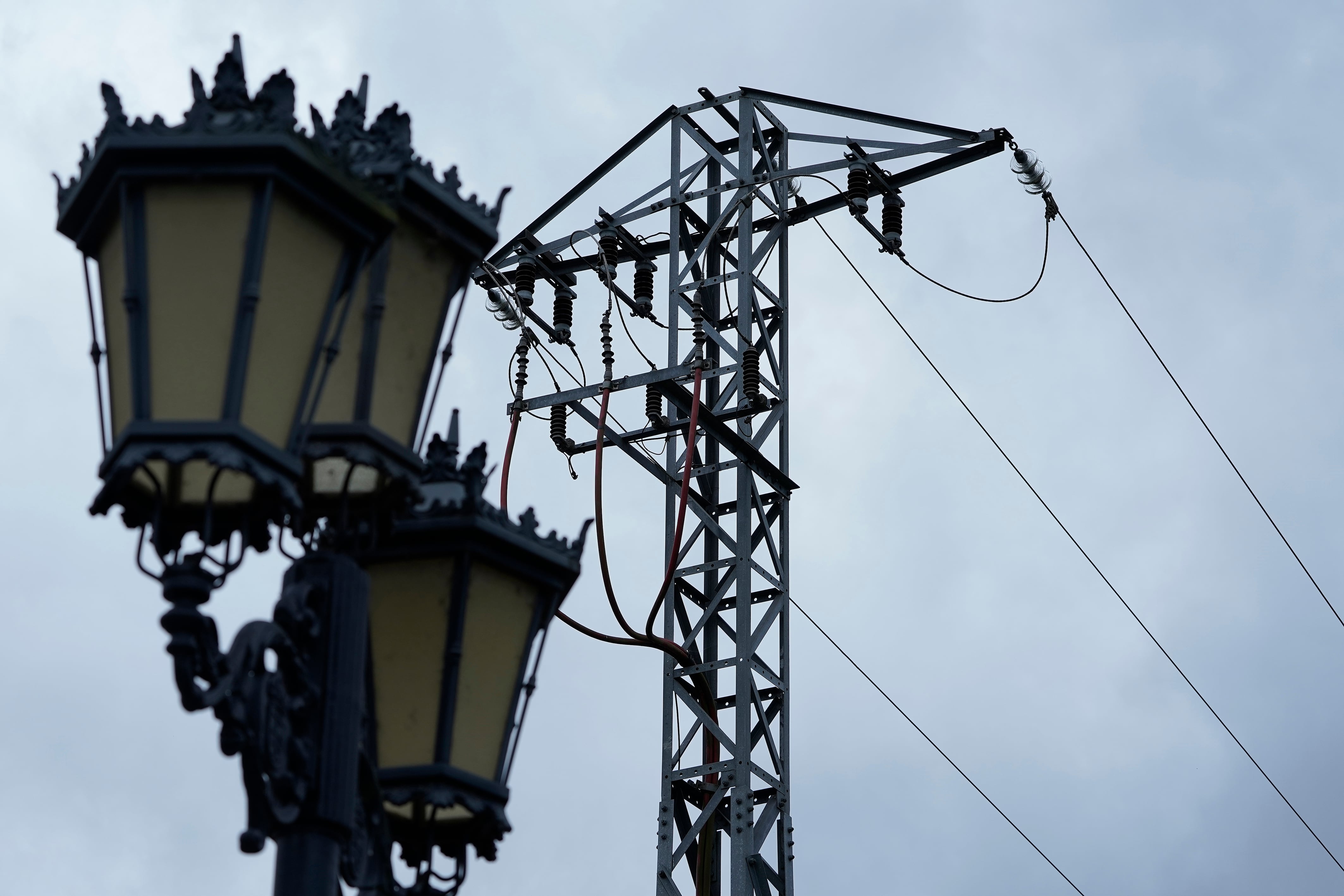 -FOTODELDIA- OVIEDO, 23/10/2022.- Una farola junto a una torreta de la luz. El precio de la electricidad en el mercado mayorista subirá mañana un 50,7 %, hasta los 109,78 euros el megavatio hora (MWh), en el que será el quinto día consecutivo en que no aplica el llamado &quot;mecanismo ibérico&quot;, de acuerdo a los resultados de la subasta celebrada este domingo. EFE/Paco Paredes
