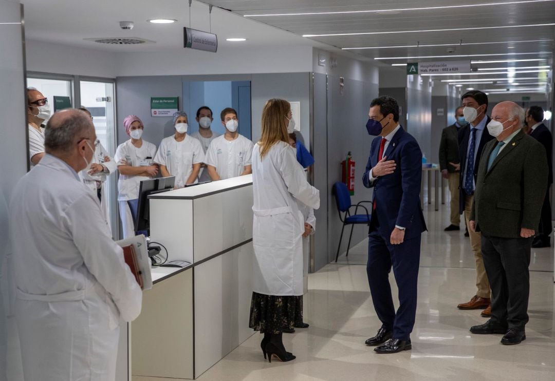 El presidente de la Junta, Juanma Moreno (c), , junto al vicepresidente Juan Marín (2d), y el consejero de Salud, Jesús Aguirre (d), conversa con el personal sanitario del nuevo Hospital de Emergencia Covid-19, construido en el antiguo Hospital Militar Vi