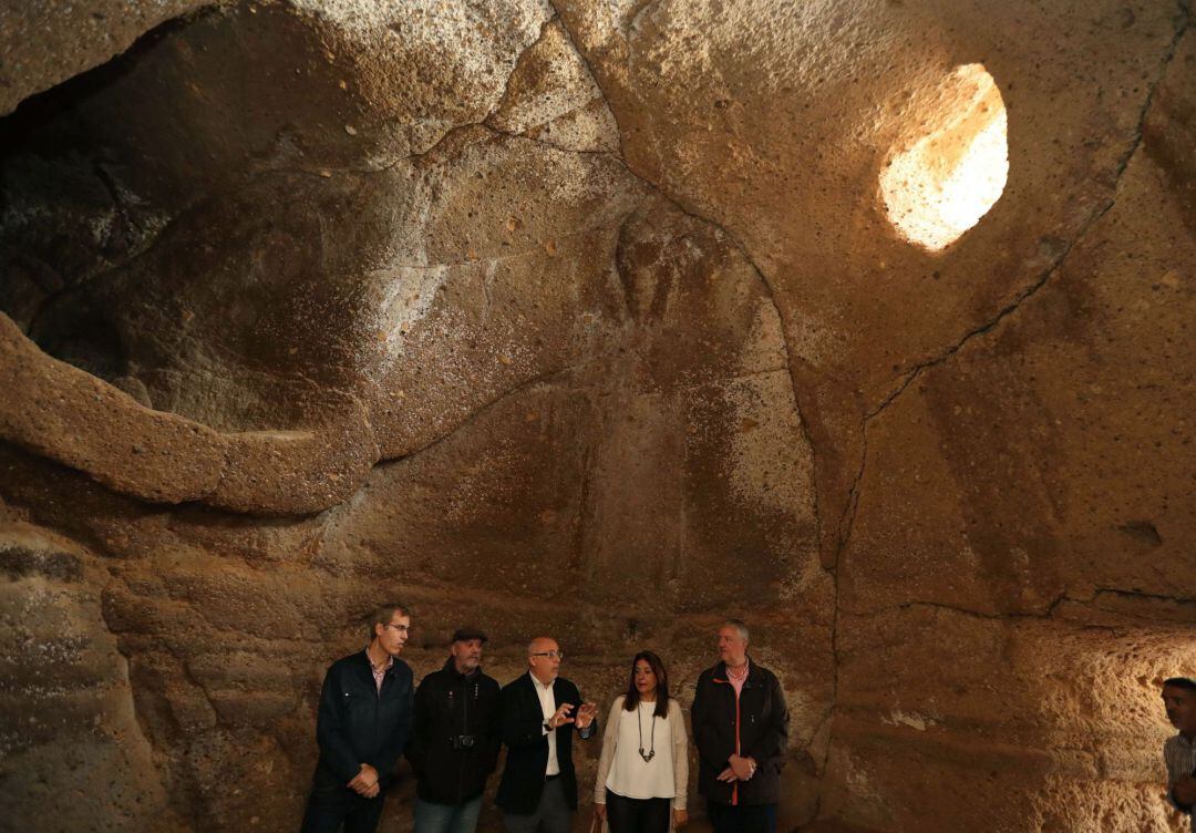 El presidente del Cabildo de Gran Canaria, Antonio Morales (c), la alcaldesa de Telde, Carmen Hernández (2d) y el arqueólogo y director del proyecto de Risco Caído, Julio Cuenca (2i), durante su visita a la Cueva de Tara.