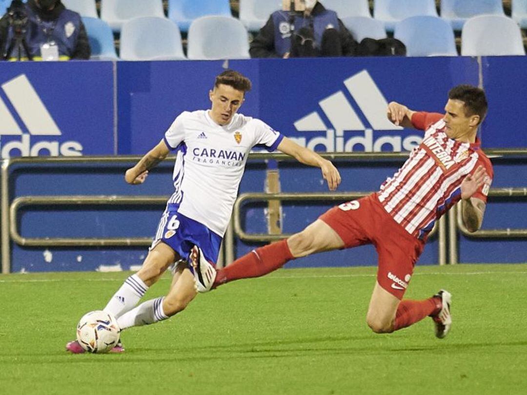 Francés se quita el balón de encima ante la entrada de un jugador del Sporting