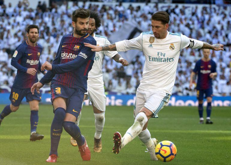 Piqué y Sergio Ramos disputan un balón durante el encuentro entre el FC Barcelona y el Real Madrid.