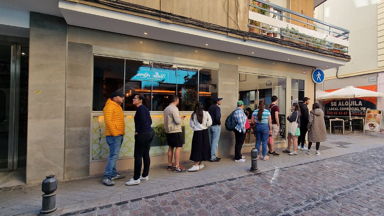 Turistas extranjeros hacen cola a las puertas de una cafetería en el centro de Granada esta primavera de 2024