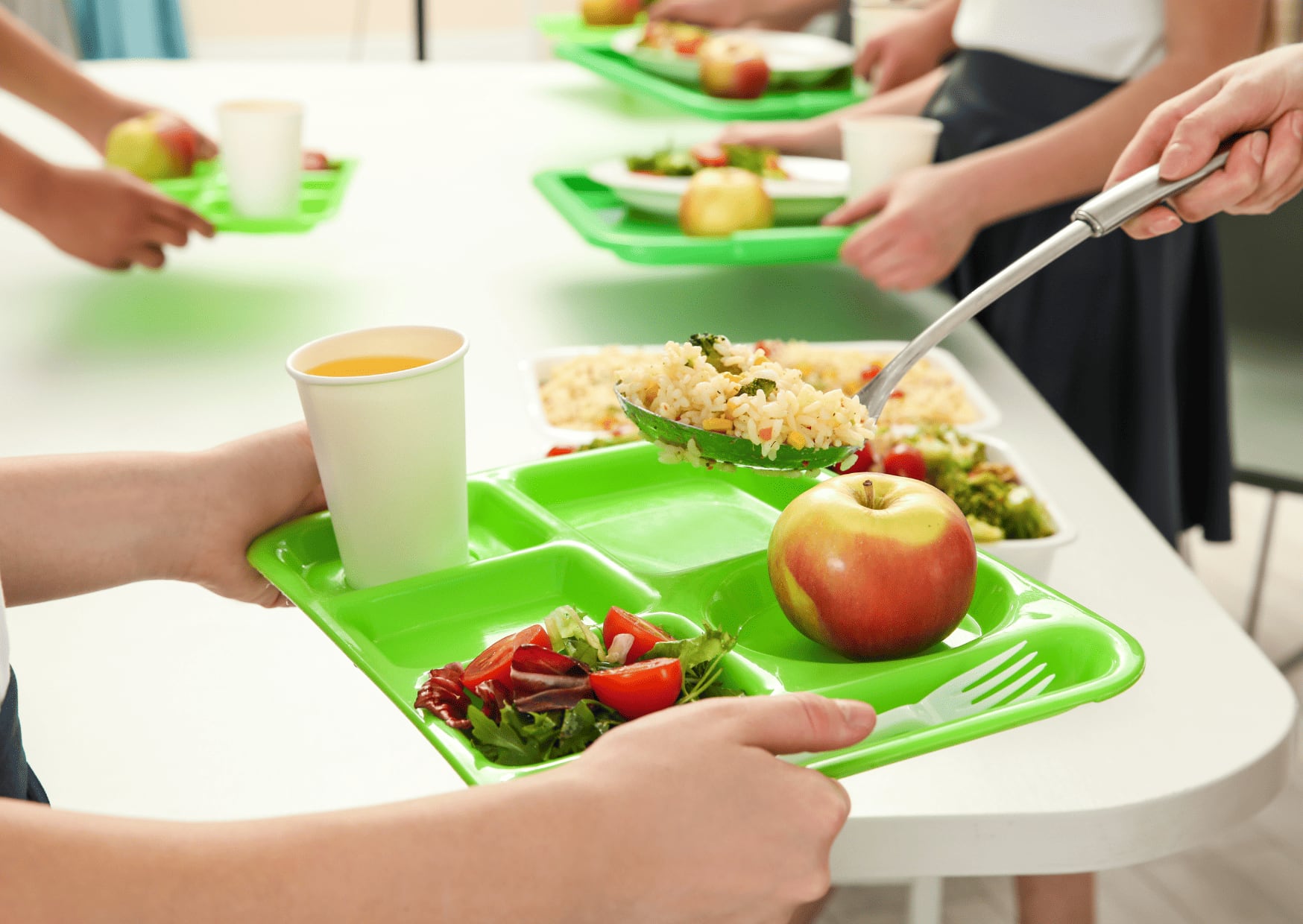 Niño sujetando una bandeja en un comedor escolar