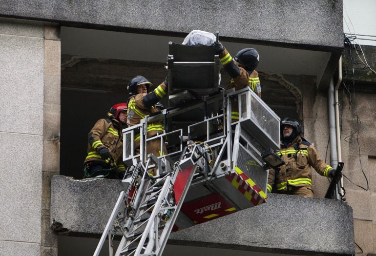 Los bomberos extraen el cuerpo de la persona fallecida, de la que aún se desconoce identidad y género, a causa de una explosión de gas en una vivienda de la calle San Salvador en Vigo.  EFE Salvador Sas