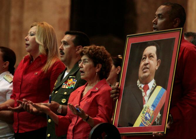 Un hombre venezolano sostiene un retrato del presidente Hugo Chávez durante la misa multitudinaria celebrada por la salud del comandante en La Habana