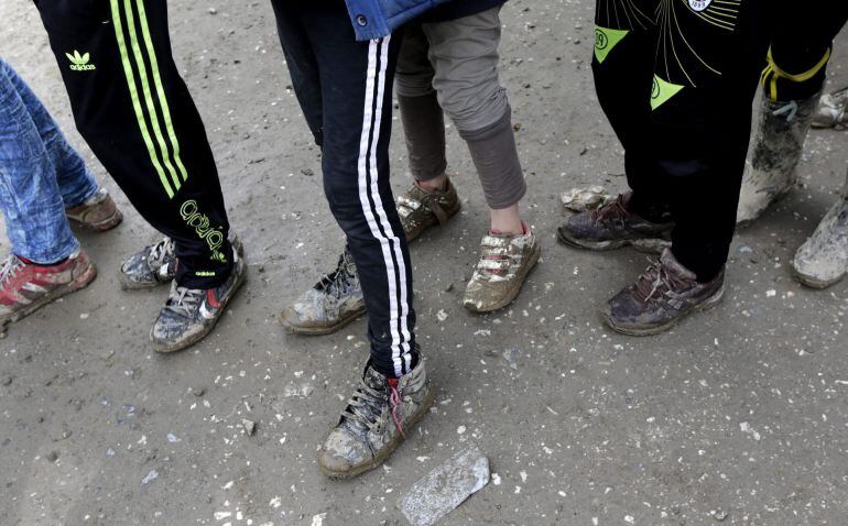 Varios refugiados hacen cola para recibir alimentos.