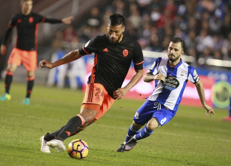 GRA292. A CORUÑA, .- El defensa argentino del Valencia CF Ezequiel Garay (i) se escapa del turco Emre Colak, del Deportivo de La Coruña, durante el partido de la décima jornada de Liga en Primera División que se disputa esta noche en el estadio Riazor, en