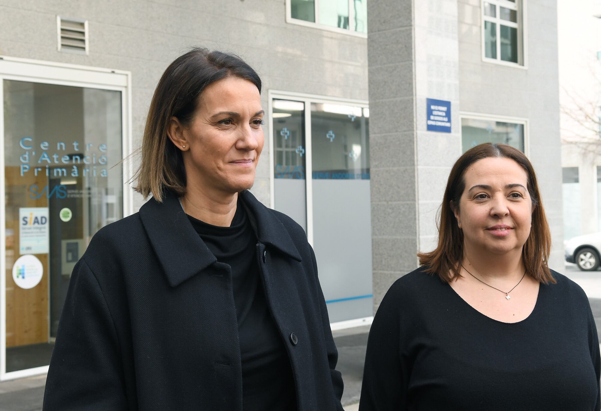 La secretària d'Estat de Salut, Cristina Pérez (e) i la llevadora referent del SIAD, Noemí Morell, davant el servei durant la presentació del balanç d'activitat del 2023.