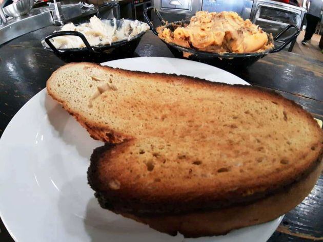 Rebanada de pan de campo y mantecas en el bar Ciudad del Transporte