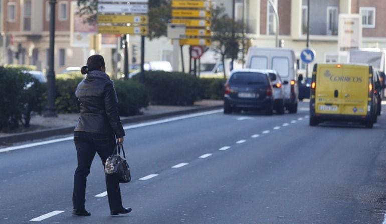 Un peatón cruza indebidamente la calle hablando por el teléfono móvil