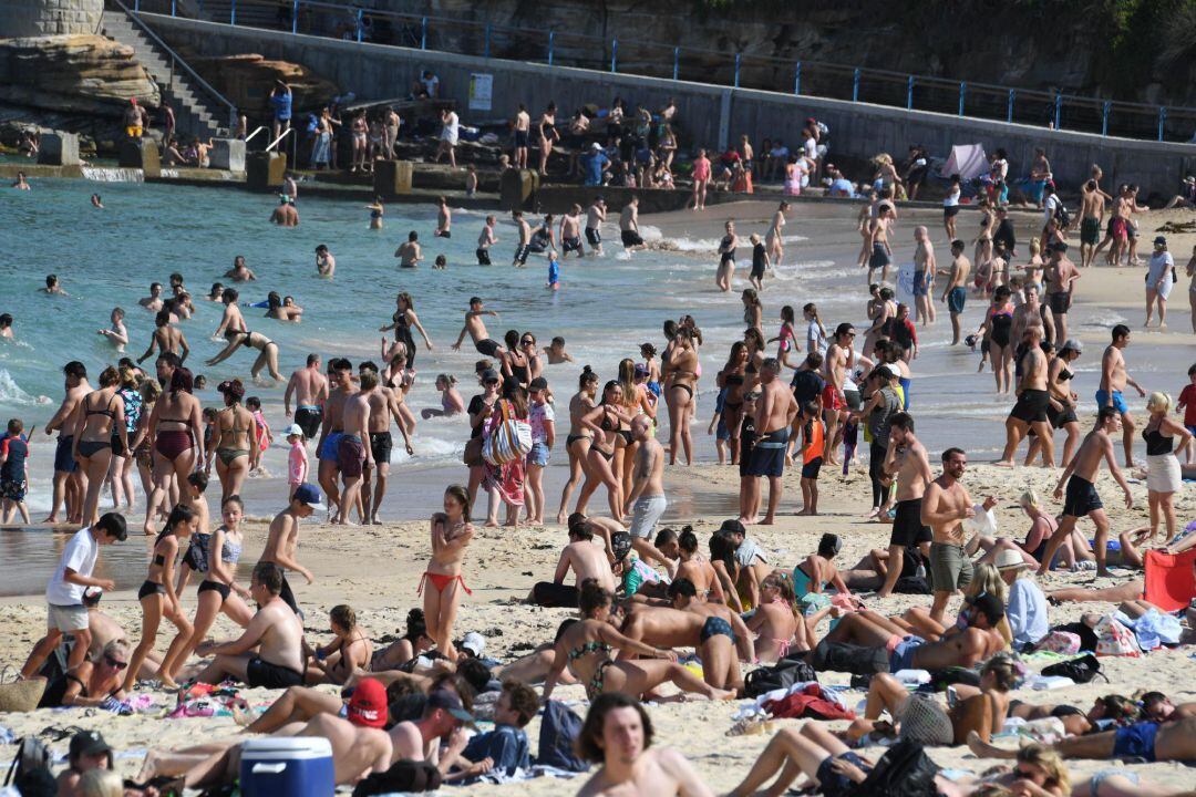 Bañistas disfrutan del sol y el agua en una playa de Australia. 