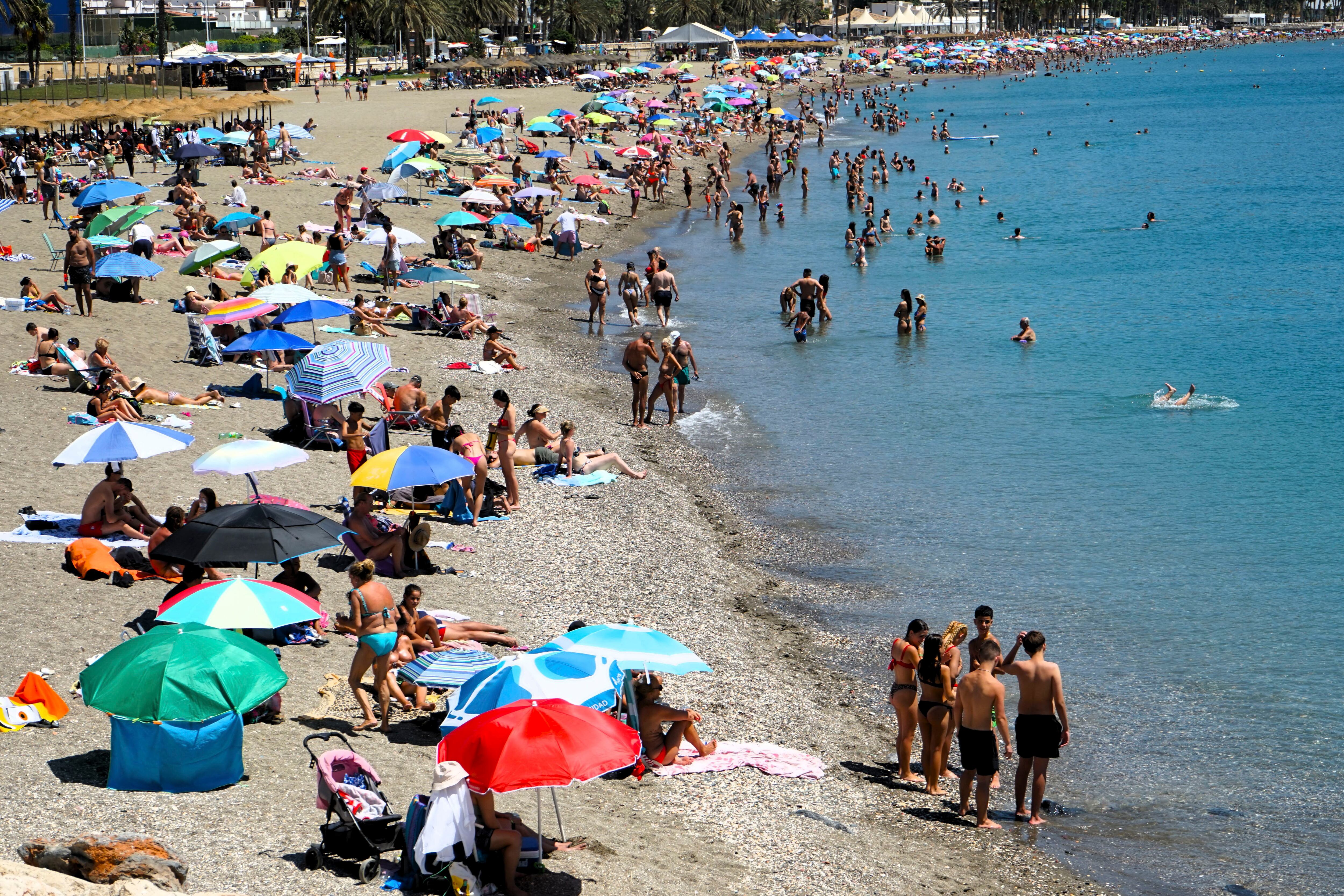 Numerosas personas se refrescan en la Playa de la Malagueta de Málaga durante el domingo, cuando la Agencia Estatal de Meteorología (Aemet) elevó a naranja la alerta por altas temperaturas. EFE/ María Alonso