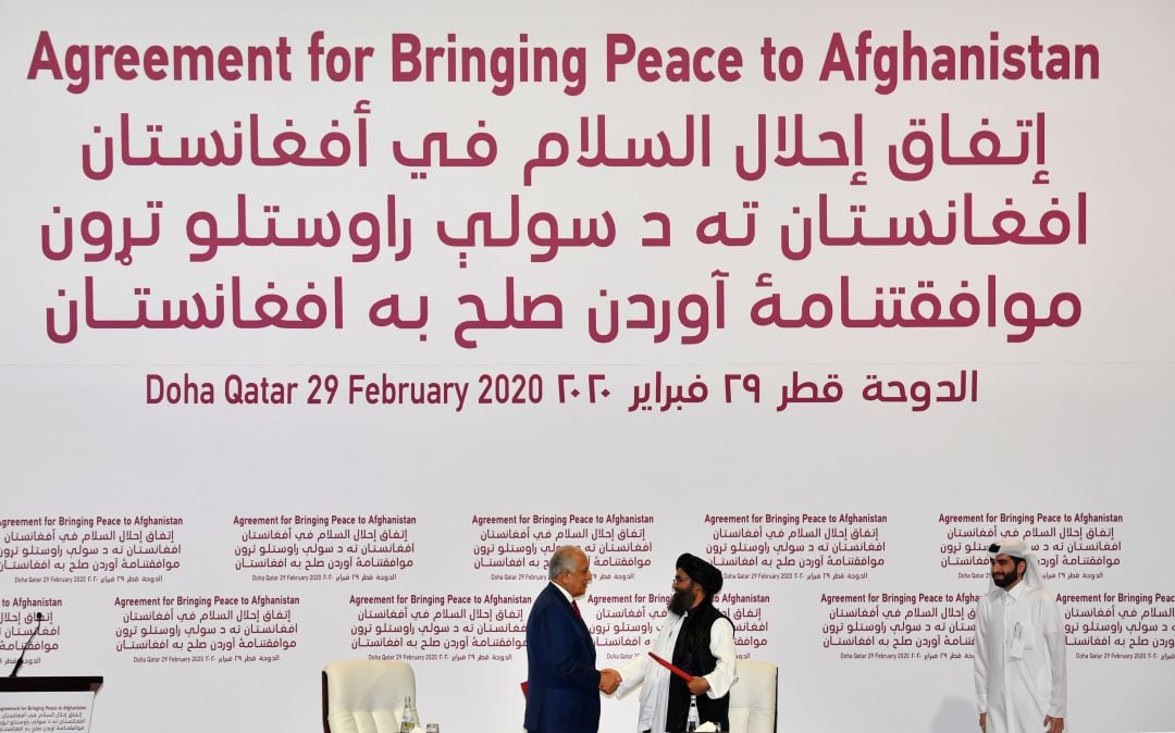 El Representante Especial de Estados Unidos para la Reconciliación de Afganistán, Zalmay Khalilzad, y el cofundador talibán, Mullah Abdul Ghani Baradar, se dan la mano después de firmar un acuerdo de paz durante una ceremonia en la capital de Qatar, Doha.