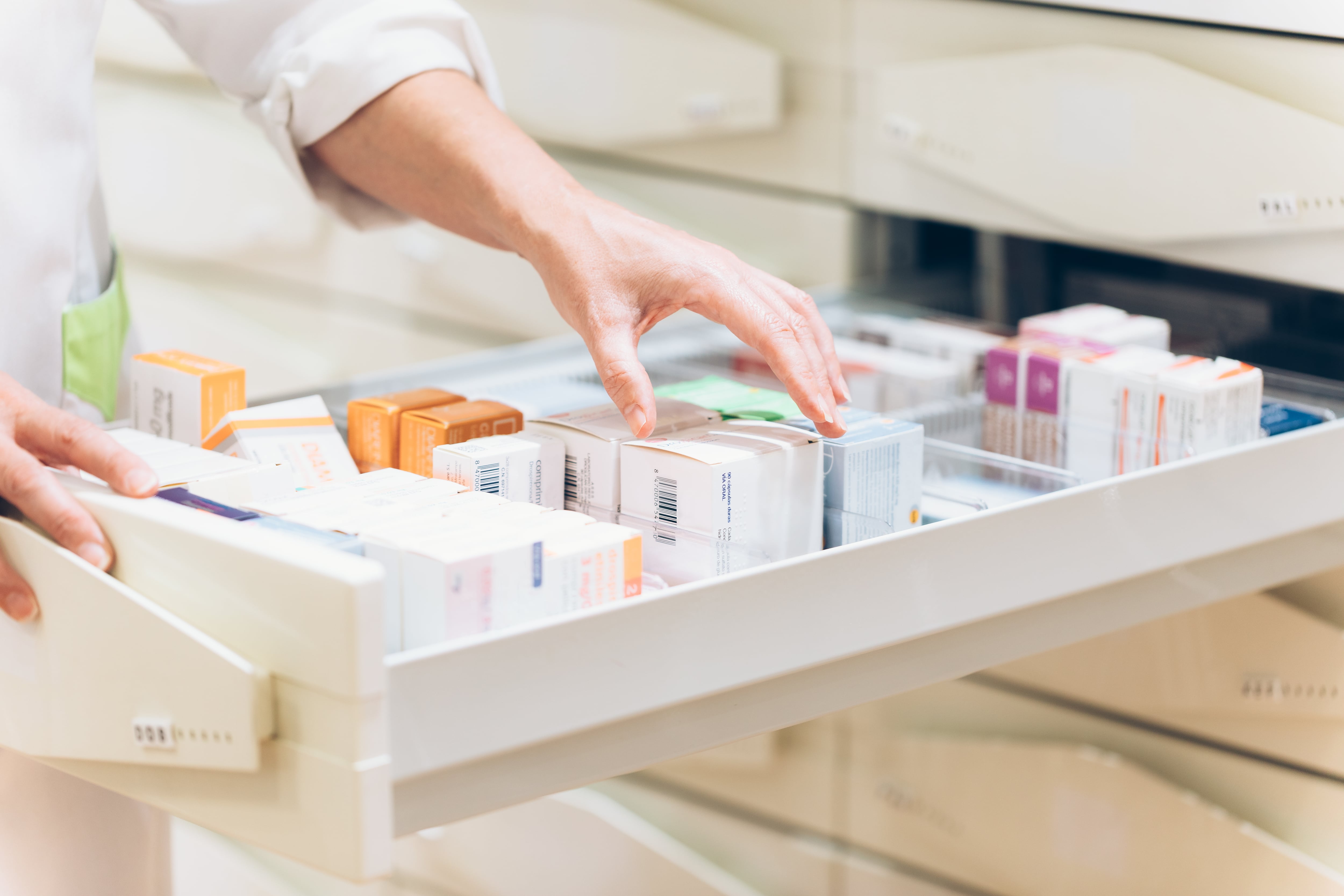 Close up of pharmacist hand taking meds from drawer