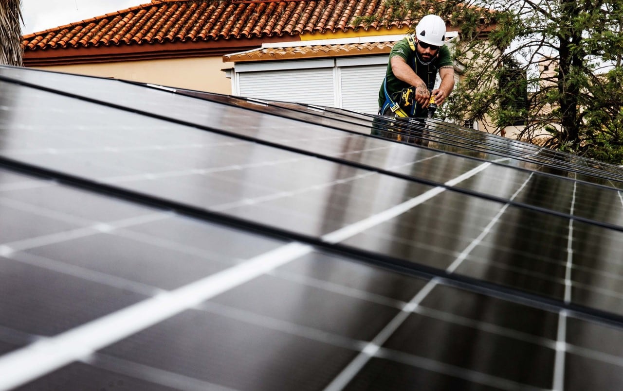 Instalador de Quantica Renovables colocando placas solares en el tejado de una vivienda