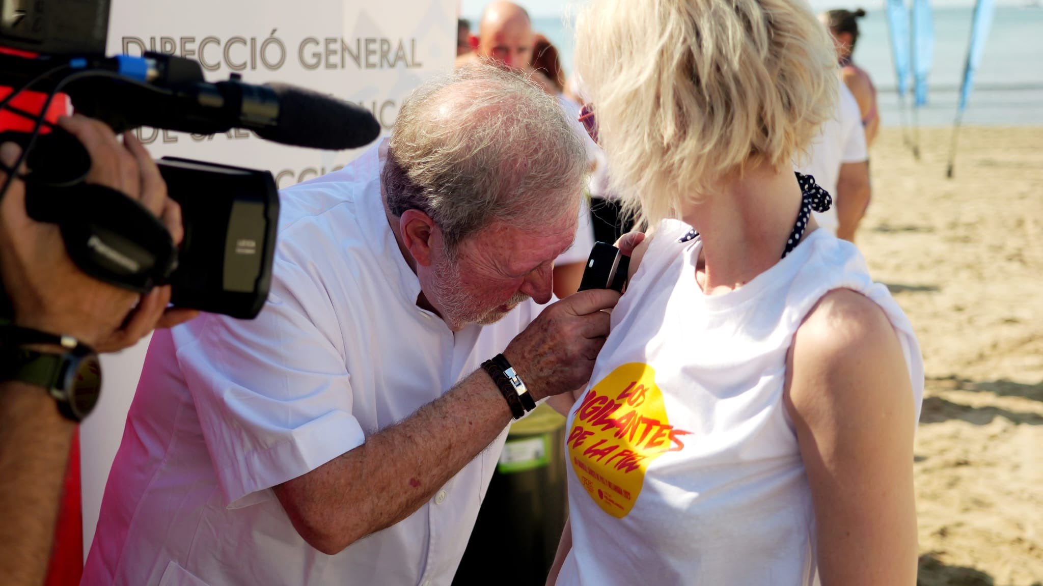 El dermatólogo Manuel Asín realiza una dermatoscopia en la playa del Postiguet. Foto: GEPAC