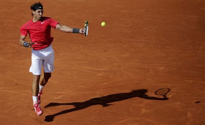 Nadal golpea a la pelota en su debút en la tierra de Roland Garros