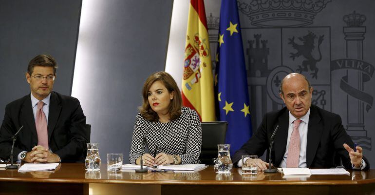 GRA139 MADRID. 3/7/2015 La vicepresidenta del Gobierno Soraya Sáenz de Santamaría junto a los ministros de Justicia, Rafael Catalá, (iz),y Economía, Luis de Guindos, durante la rueda de prensa posterior a la reunión del Consejo de Ministros de hoy. EFE/Se
