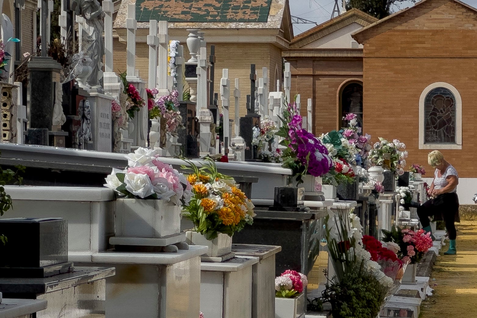 Personas limpian y colocan flores como preparativo del Día de Todos los Santos