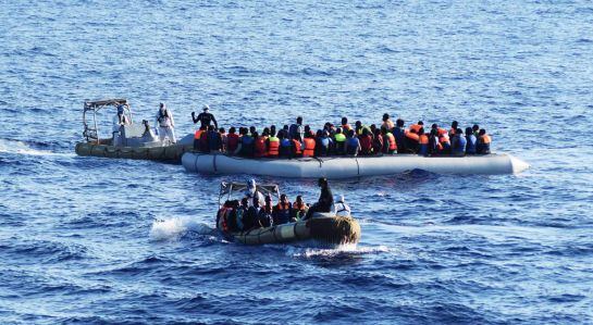 LIB03 ALTA MAR (---) 30/08/2016.- Fotografía facilitada hoy, 30 de agosto de 2016, por la Armada italiana muestra a varios miembros del ejército italiano mientras ayudan a decenas de inmigrantes durante una operación de rescate en el mar Mediterráneo, cer