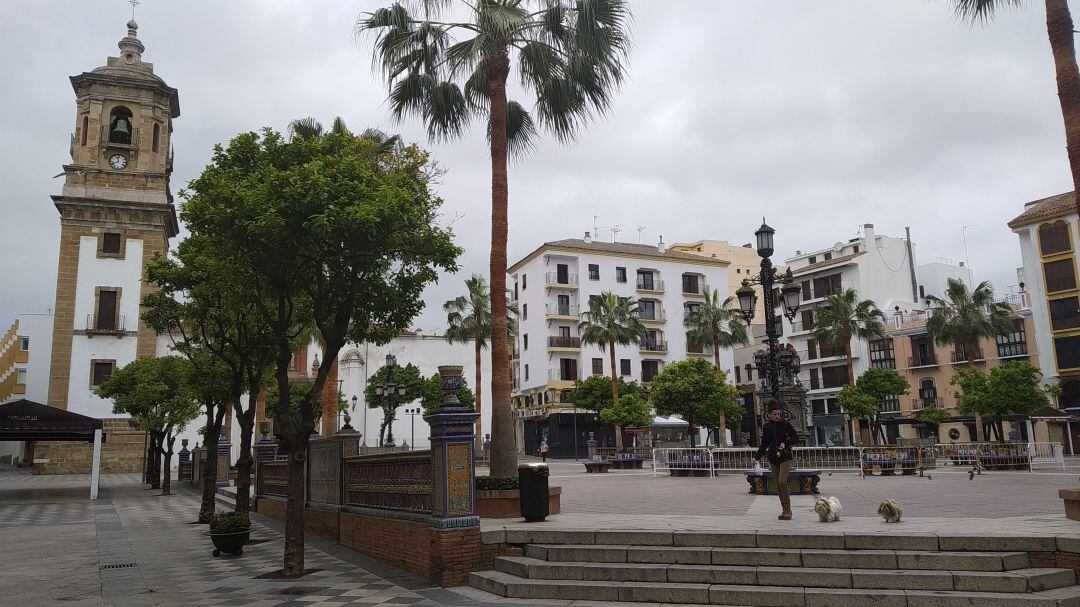 Una mujer pasea sus mascotas por la solitaria Plaza Alta de Algeciras.