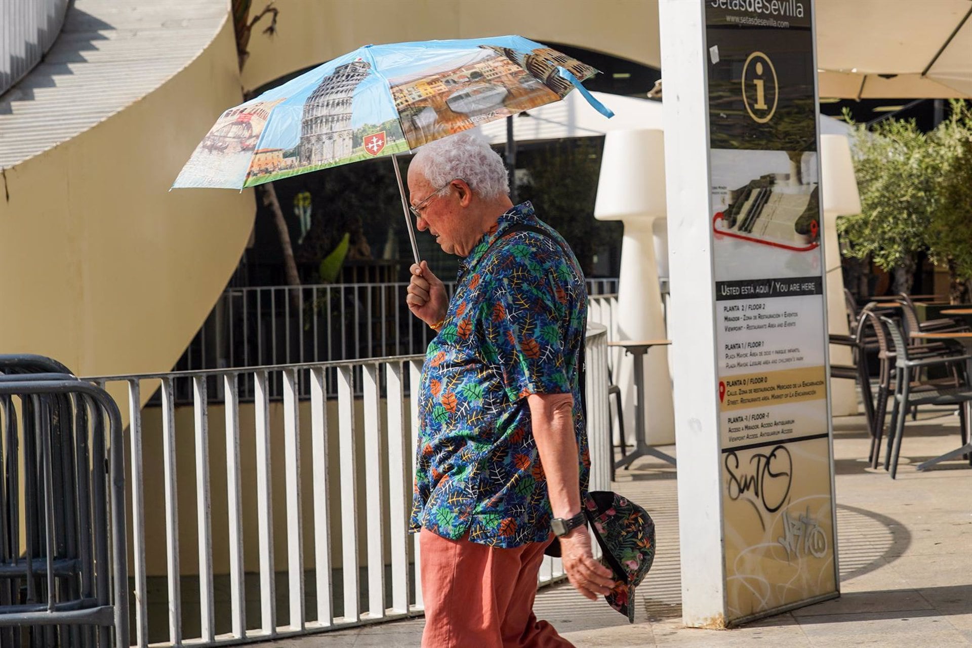 Un turista con un paraguas por la Setas en otro día con altas temperaturas en la capital andaluz / Europa Press