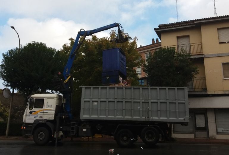 Operarios de una empresa de recogida de papel vacían uno de los contenedores en un camión.