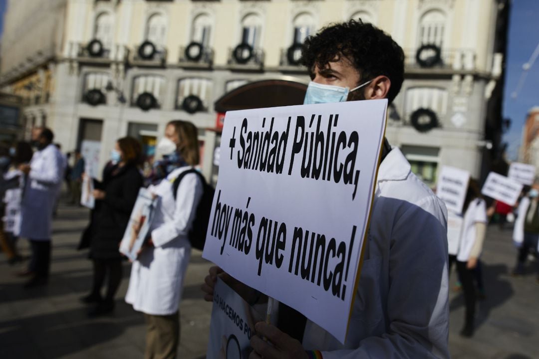 Archivo - Un trabajador sanitario sostiene una pancarta durante una concentración convocada por la Asociación de Médicos y Titulados Superiores de Madrid (AMYTS) en la Puerta del Sol en 2022