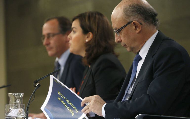 La vicepresidenta del Gobierno, Soraya Sáenz de Santamaría, junto a los ministros de Hacienda, Cristóbal Montoro  y Sanidad, Alfonso Alonso durante la rueda de prensa posterior a la reunión del Consejo de Ministros celebrada en el Palacio de la Moncloa. 